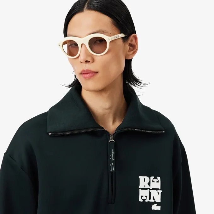 Camisola com gola alta, fecho e emblema, inspirada na passerelle