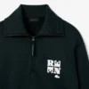 Camisola com gola alta, fecho e emblema, inspirada na passerelle